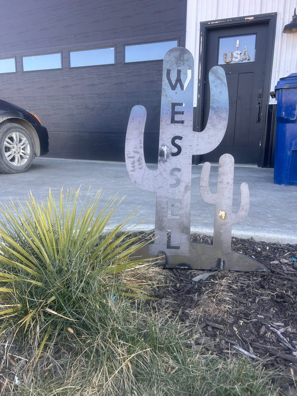 Metal U-shaped sign with text on a street next to a building